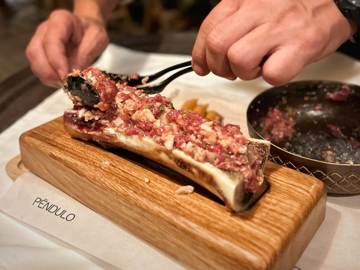 Steak tartar sobre moll de l'os del Péndulo Beach Club.
